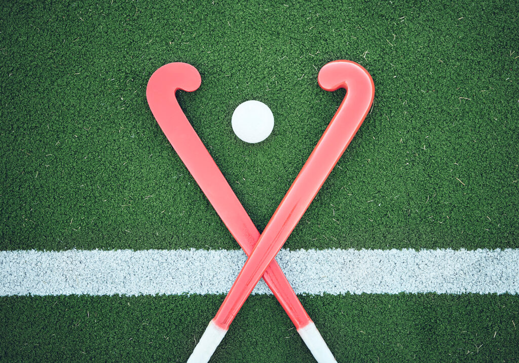 Turf field, hockey stick or sports ball on the ground for fitness competition, exercise contest or practice match. Green pitch, astroturf or cross of game equipment on the floor for training top view